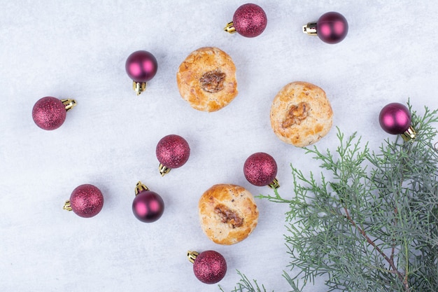 Galletas con nueces y bolas navideñas relucientes.