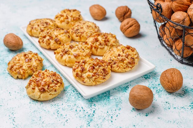 Galletas de nuez caseras en plato blanco con nueces en la mesa de luz