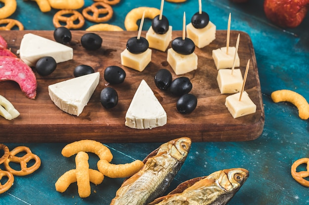 Galletas con pescado ahumado y queso sobre fondo azul.