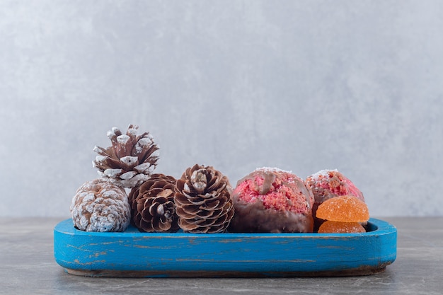 Galletas y piñas en un plato azul sobre superficie de mármol