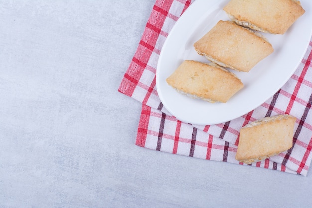 Foto gratuita galletas rellenas de crema en un plato blanco.