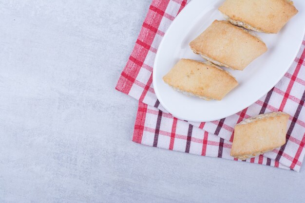 Galletas rellenas de crema en un plato blanco.