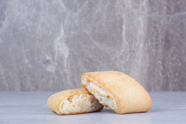 Galletas rellenas de crema sobre mesa de mármol.