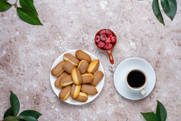 Galletas con relleno de mermelada de frambuesa y frambuesas congeladas sobre fondo claro, vista superior