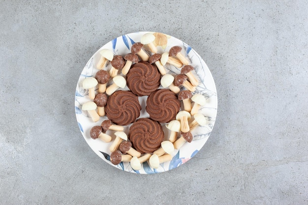 Galletas rodeadas de setas de chocolate en un plato sobre fondo de mármol. Foto de alta calidad