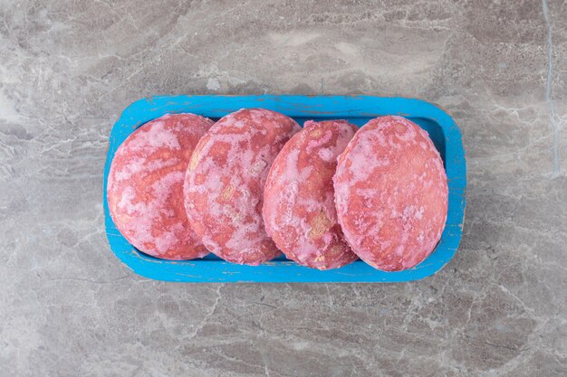 Galletas rosadas en un plato sobre la superficie de mármol