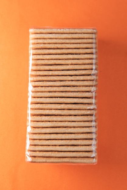 Foto gratuita galletas de sal en la mesa naranja