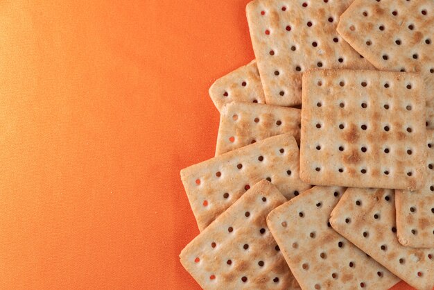 Galletas de sal sobre fondo naranja