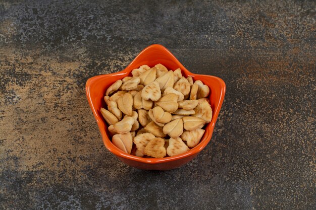 Galletas saladas en forma de corazón en un tazón de naranja.