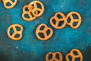 Foto gratuita galletas saladas de pretzel sobre un fondo azul de madera