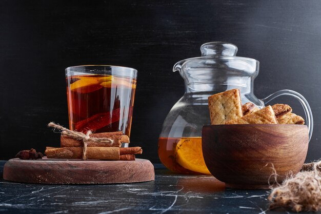 Galletas saladas servidas con un vaso de té.