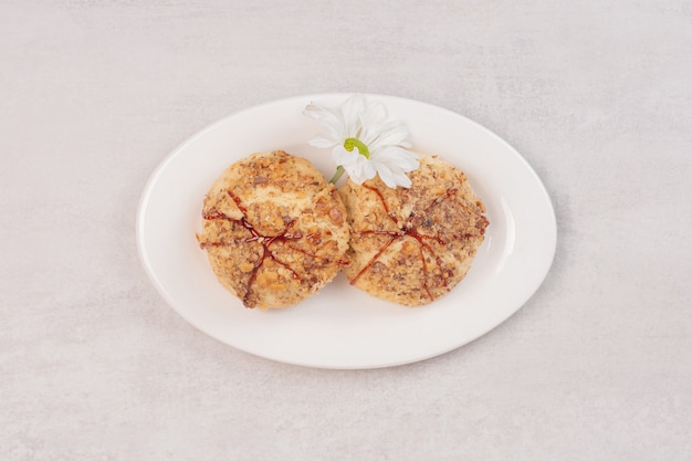 Galletas con salsa de caramelo y flor en blanco.