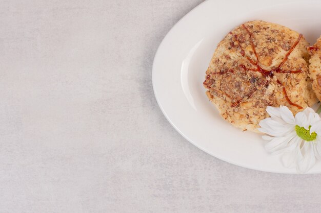 Galletas con salsa de caramelo y flor en blanco.