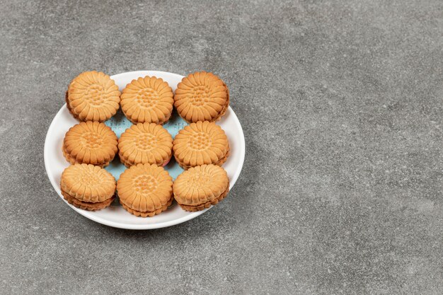 Galletas sandwich rellenas con crema en la placa blanca.