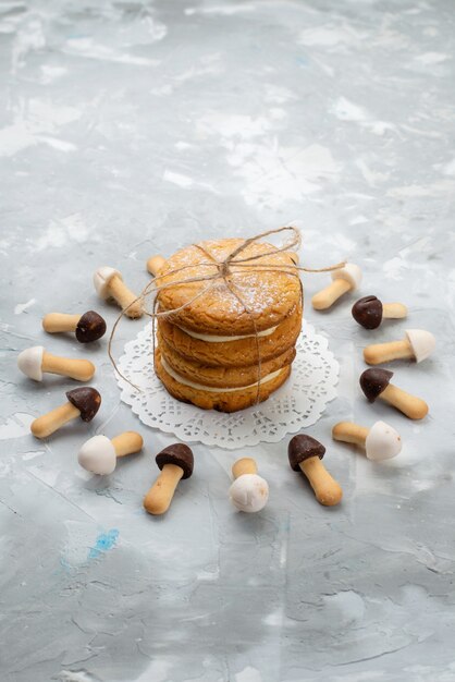 Galletas sándwich de vista superior con relleno de crema y galletas en la crema dulce de azúcar de escritorio gris