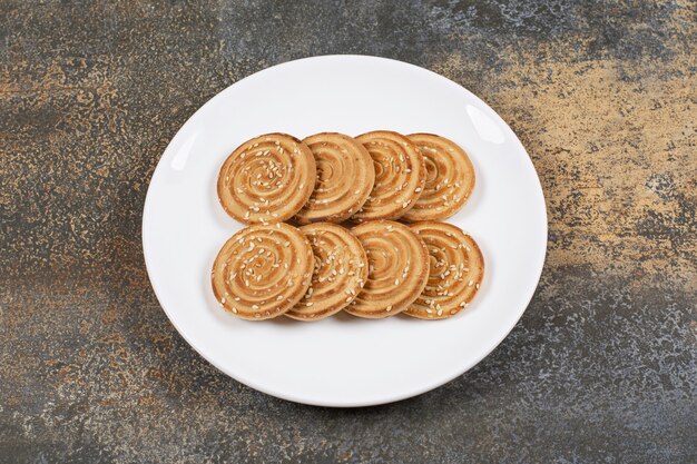 Galletas de semillas de sésamo en un plato blanco.