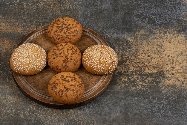 Galletas con semillas de sésamo y trozos de chocolate sobre tabla de madera.