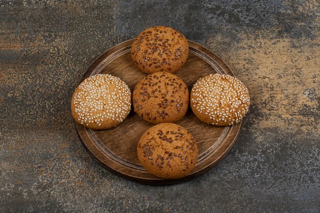 Galletas con semillas de sésamo y trozos de chocolate sobre tabla de madera.