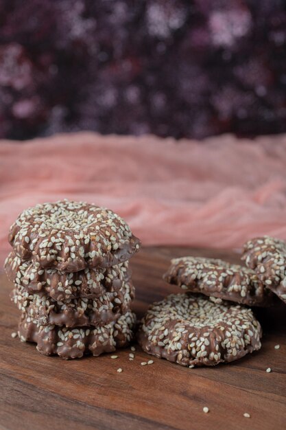 Galletas de sésamo de cacao aisladas sobre tabla de madera.