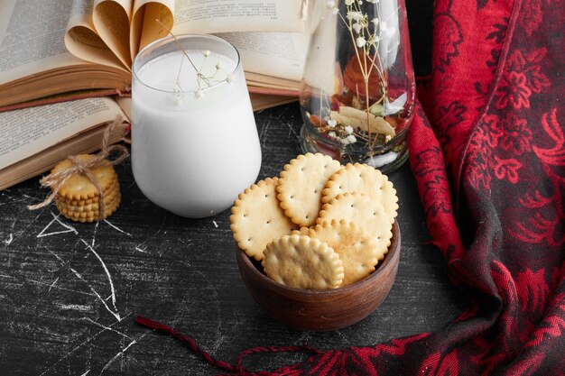 Galletas en una taza de madera con leche.