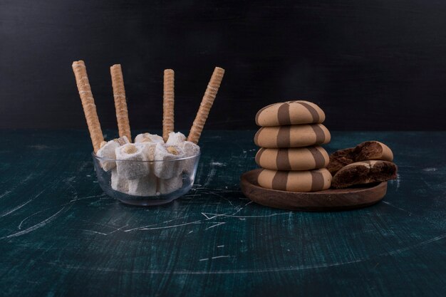 Galletas de vainilla y cacao en un plato de madera con gofres a un lado