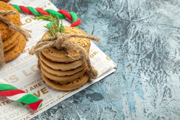 Galletas de vista frontal atadas con una cuerda dulces de Navidad sobre fondo gris espacio libre