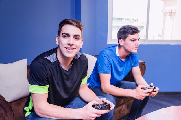 Foto gratuita gamers con gamepad en sofá