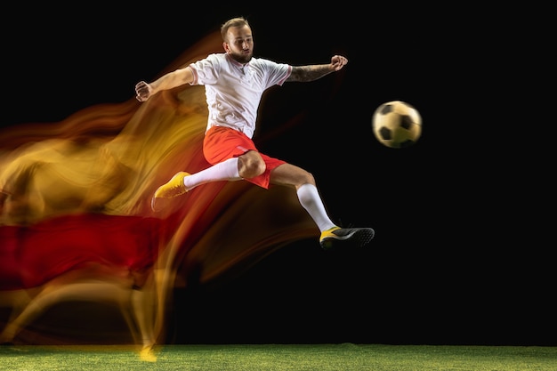 Para ganar. Jugador de fútbol o fútbol masculino caucásico joven en ropa deportiva