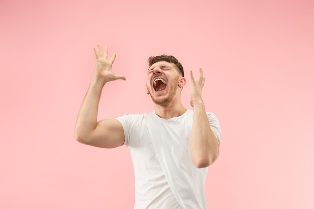 Gané. Hombre feliz de éxito ganador celebrando ser un ganador. Imagen dinámica del modelo masculino caucásico en el espacio rosa. Victoria, concepto de deleite