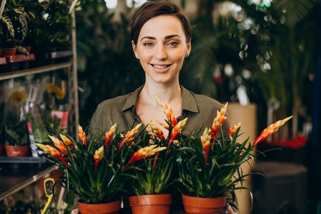 Gardner hembra en casa de plantas con plantas y flores.