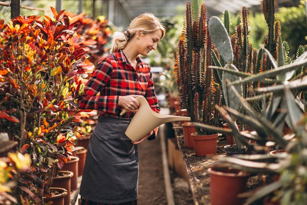 Gardner mujer cuidando las plantas en un invernadero