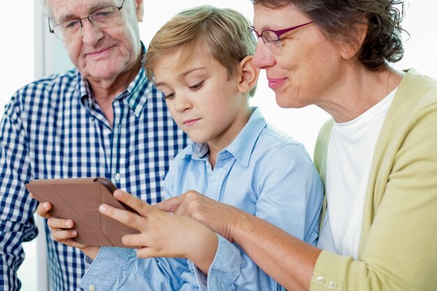 el gasto de edad avanzada que usa la tableta niño