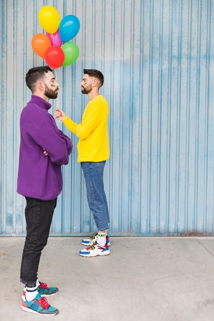 Gay con globos parados uno frente al otro