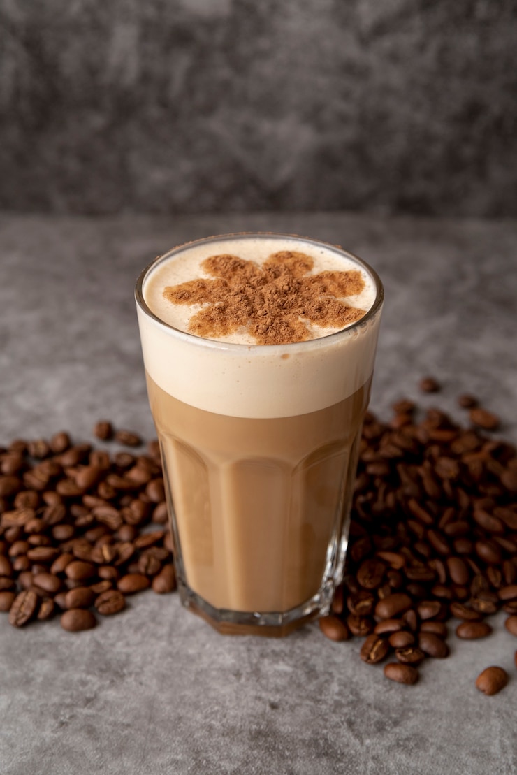Photo Gratis gelas cappucino tampilan tinggi dengan biji kopi