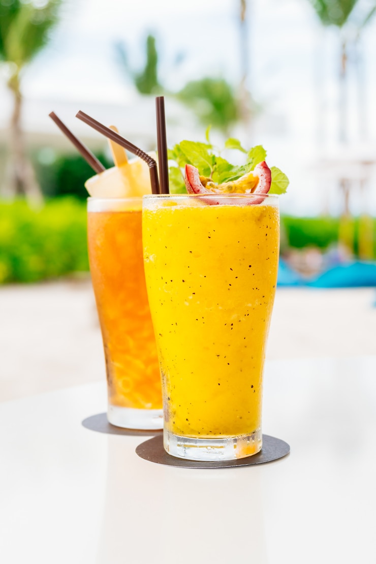 Gelas minuman koktail es dengan pantai dan laut