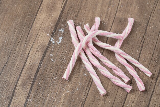 Gelatina de forma de espiral rosa se pega sobre una mesa de madera.