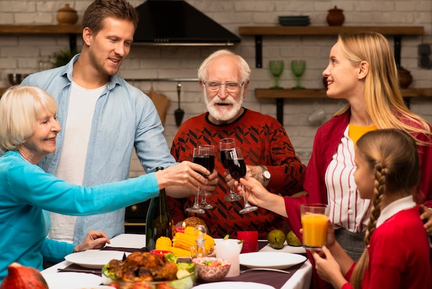 Generaciones familiares que tuestan vasos el día de acción de gracias