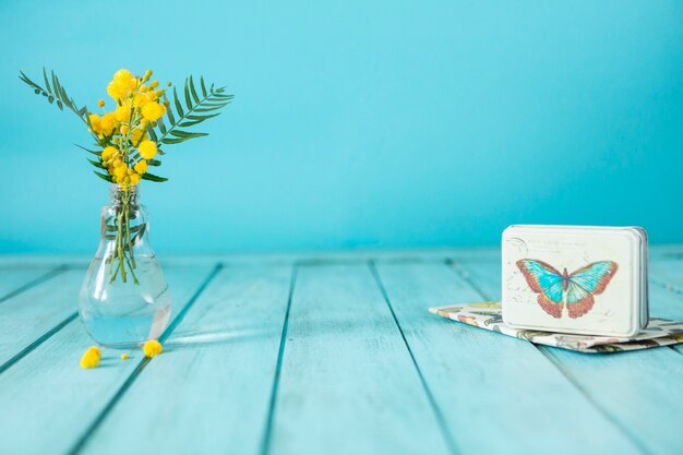 Genial composición con flores amarillas y caja de metal