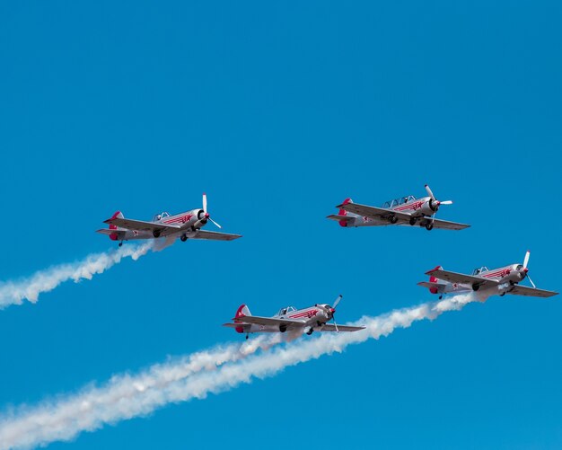 Genial espectáculo de aviones con aviones volando y humo blanco en el cielo azul