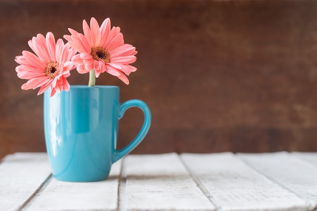 Genial fondo con taza azul decorativa y flores