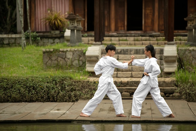 Foto gratuita gente al aire libre en la naturaleza entrenando para taekwondo