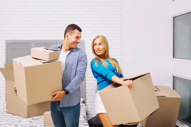 Gente alegre con cajas en casa nueva