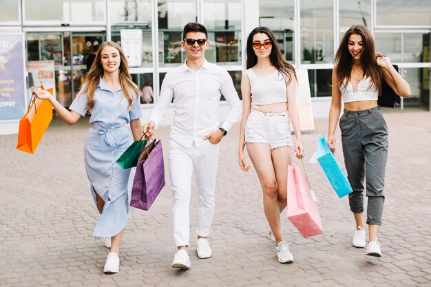 Gente alegre caminando felizmente con las compras