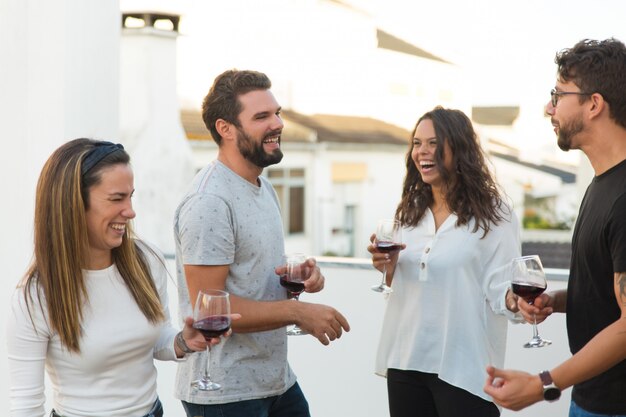 Gente alegre feliz divirtiéndose y bebiendo vino