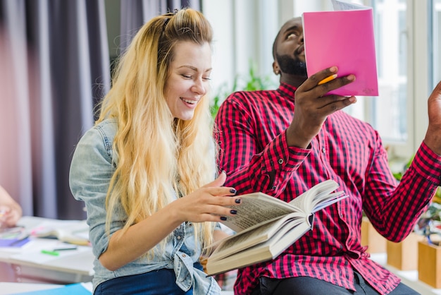 Foto gratuita gente alegre trabajando con libros de texto