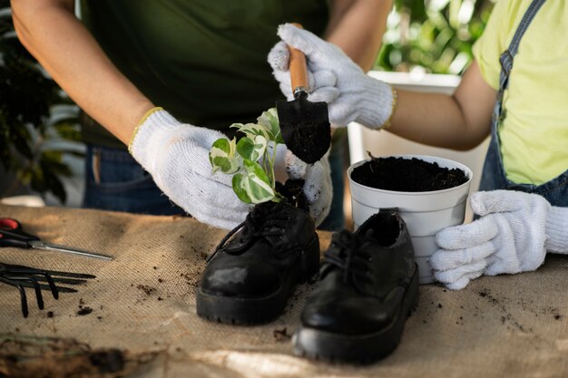 Gente de alto ángulo haciendo jardinería con zapatos viejos.