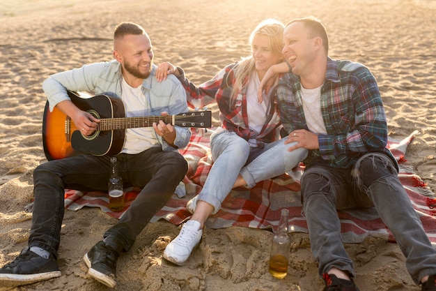 Gente de alto ángulo pasar tiempo juntos en la playa