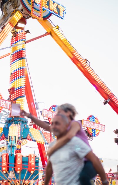 Gente de ángulo bajo divirtiéndose en el parque de atracciones