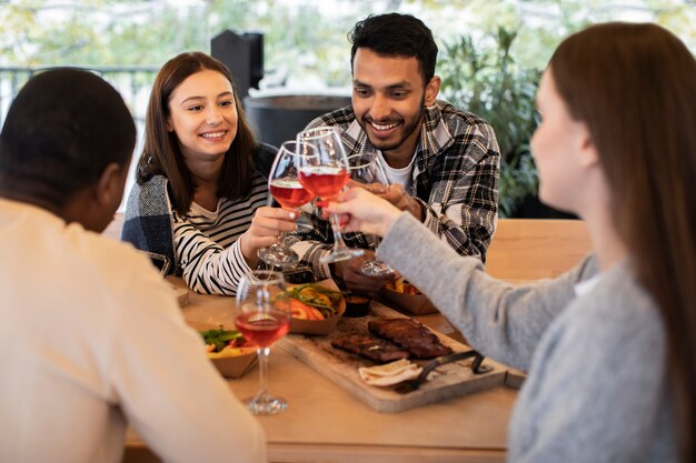 Gente animando con copas de vino en una reunión