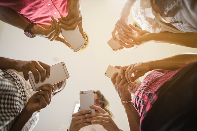 Foto gratuita gente anónima ocupada con teléfonos inteligentes